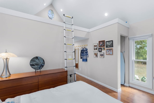 bedroom featuring high vaulted ceiling and hardwood / wood-style floors