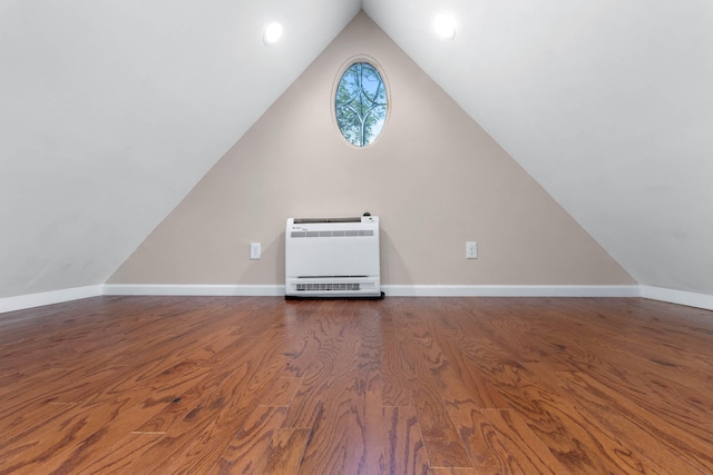 bonus room featuring heating unit, lofted ceiling, and dark hardwood / wood-style floors