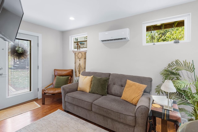 living room with a wealth of natural light, a wall unit AC, and wood-type flooring