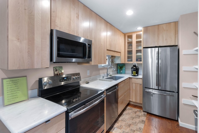 kitchen featuring appliances with stainless steel finishes, hardwood / wood-style floors, light brown cabinetry, and sink