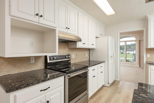 kitchen featuring white refrigerator with ice dispenser, light wood-type flooring, stainless steel electric range oven, and white cabinetry