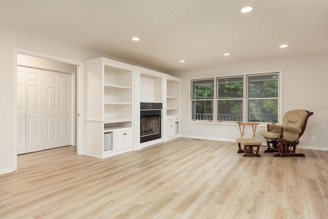 sitting room featuring light hardwood / wood-style flooring and a textured ceiling