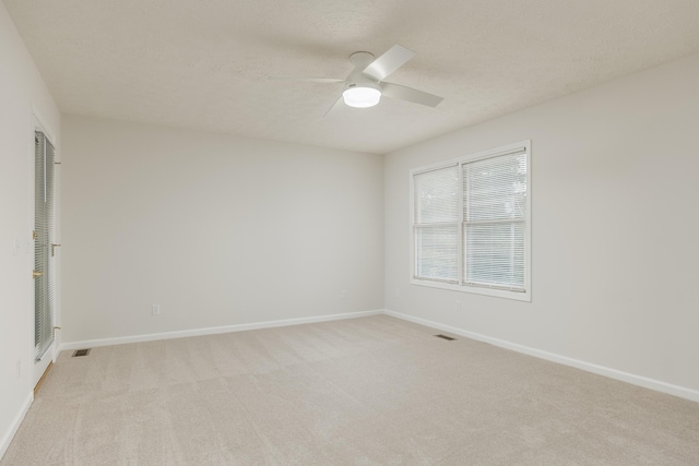 carpeted empty room featuring ceiling fan and a textured ceiling