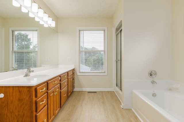 bathroom featuring wood-type flooring, vanity, shower with separate bathtub, and a textured ceiling