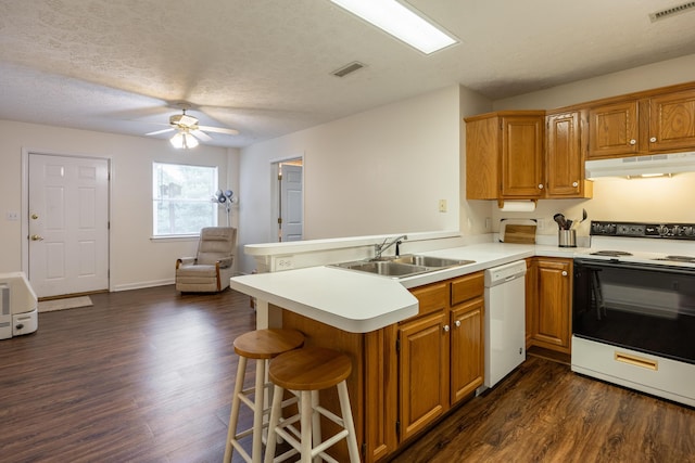 kitchen featuring white appliances, a textured ceiling, kitchen peninsula, and dark wood-type flooring