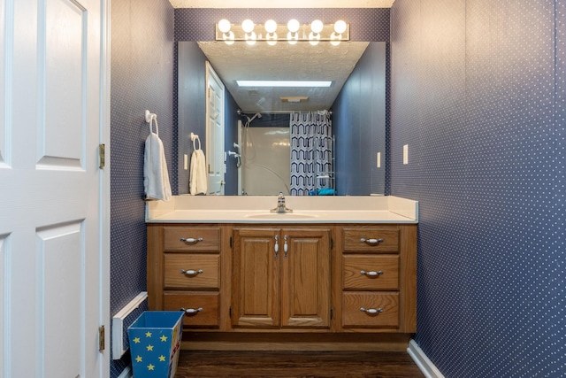 bathroom featuring wood-type flooring, a shower with curtain, a textured ceiling, and vanity