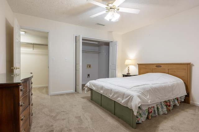 carpeted bedroom with a textured ceiling and ceiling fan