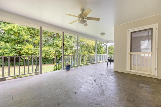 unfurnished sunroom with ceiling fan