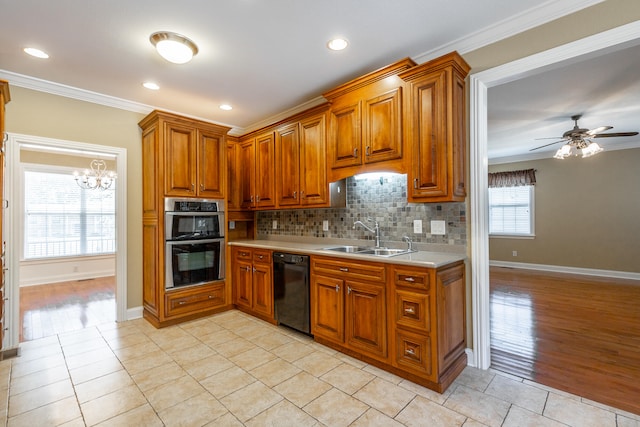 kitchen featuring double oven, dishwasher, ceiling fan with notable chandelier, and plenty of natural light