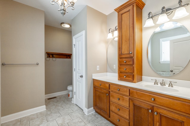 bathroom featuring an inviting chandelier, tile patterned flooring, vanity, and toilet