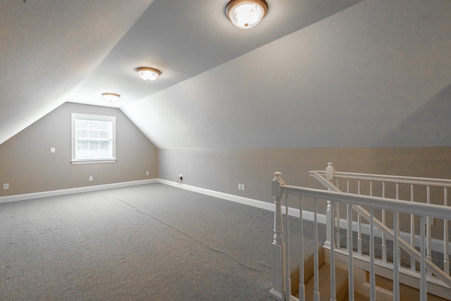 additional living space with vaulted ceiling and carpet floors