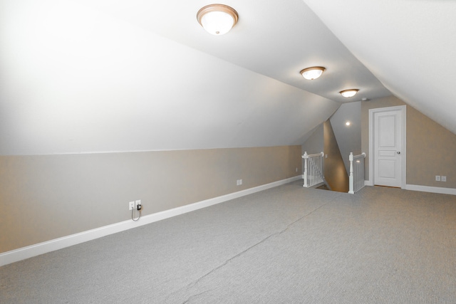 bonus room featuring vaulted ceiling and carpet