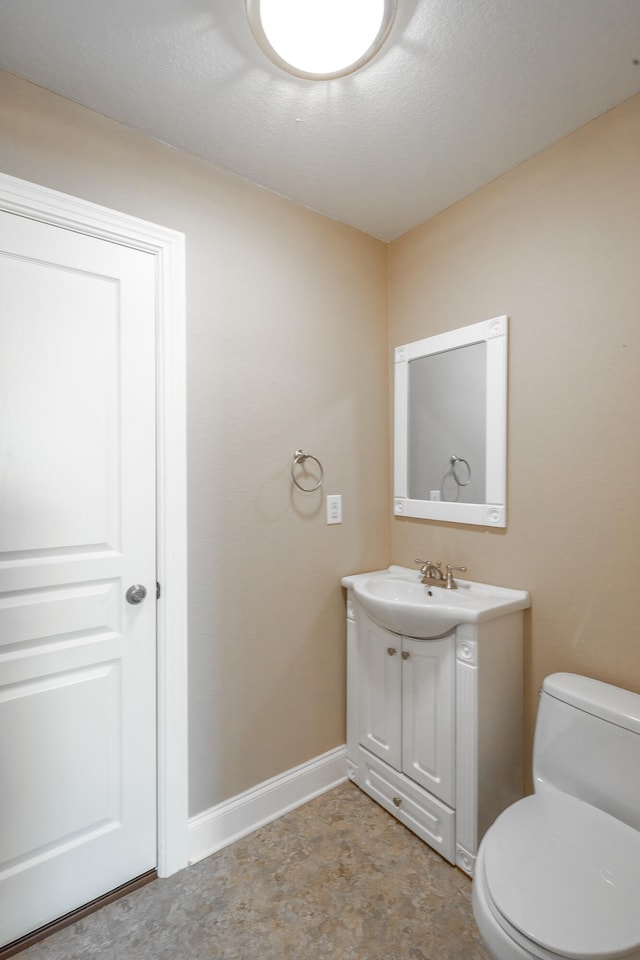 bathroom featuring vanity, toilet, and a textured ceiling