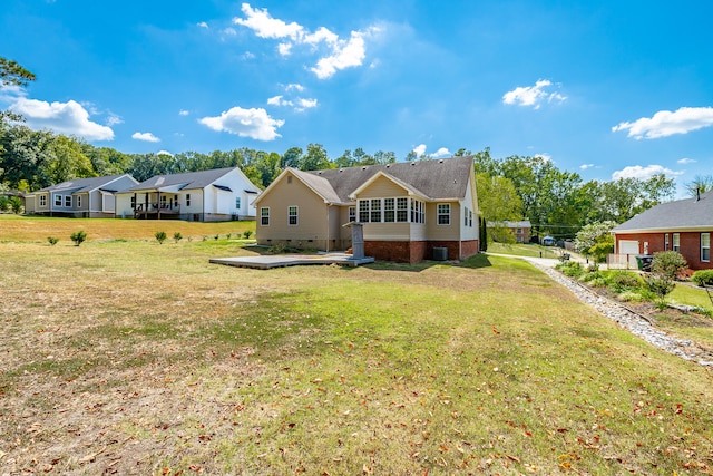 rear view of property with a lawn and central AC