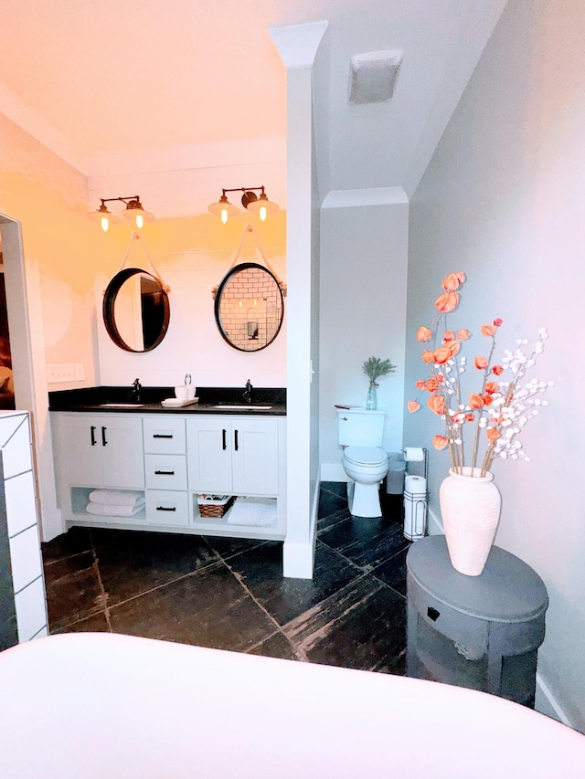 bathroom with ornamental molding, vanity, and toilet