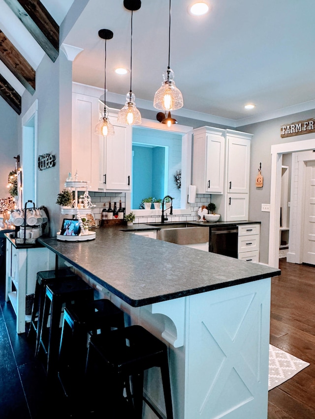 kitchen with hanging light fixtures, dark hardwood / wood-style flooring, decorative backsplash, and white cabinetry