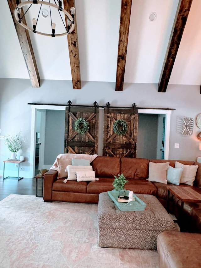 living room with beamed ceiling, a notable chandelier, and a barn door