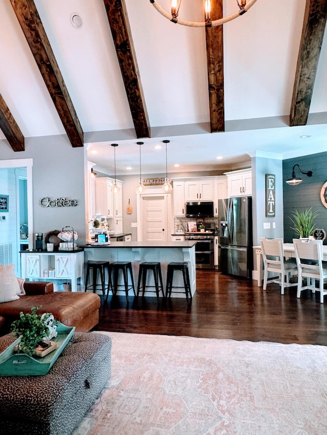 kitchen with white cabinets, hanging light fixtures, stainless steel appliances, dark hardwood / wood-style floors, and an inviting chandelier