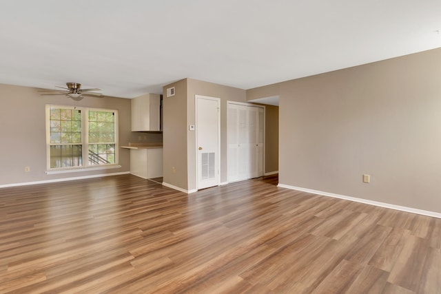 unfurnished living room featuring ceiling fan and light wood-type flooring