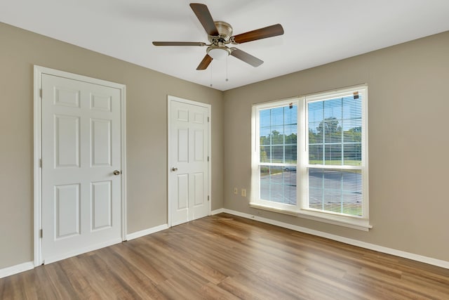 unfurnished bedroom featuring wood-type flooring and ceiling fan