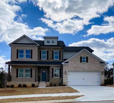 craftsman-style house with an attached garage, driveway, and brick siding