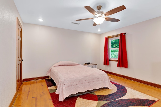 bedroom with ceiling fan and hardwood / wood-style flooring