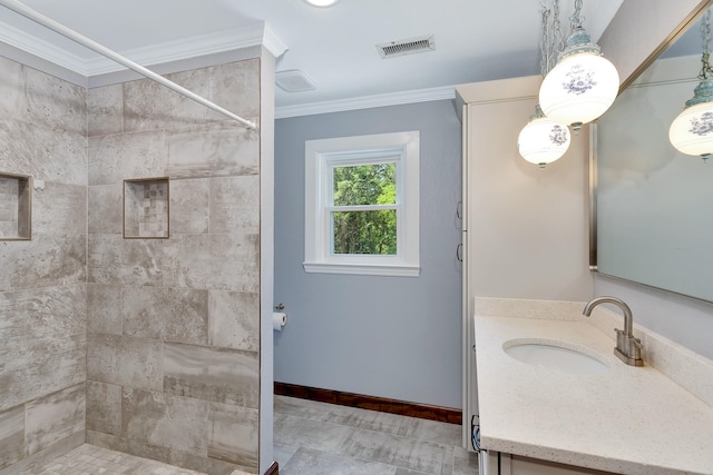 bathroom featuring ornamental molding, tile patterned floors, vanity, and tiled shower