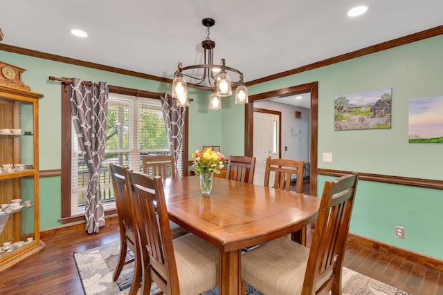 dining space with ornamental molding, a notable chandelier, and dark wood-type flooring