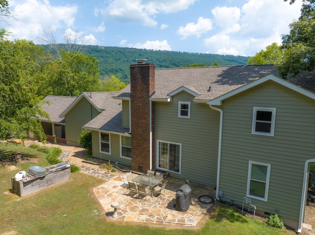 rear view of property featuring a lawn and a patio area