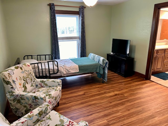 bedroom with hardwood / wood-style flooring and connected bathroom