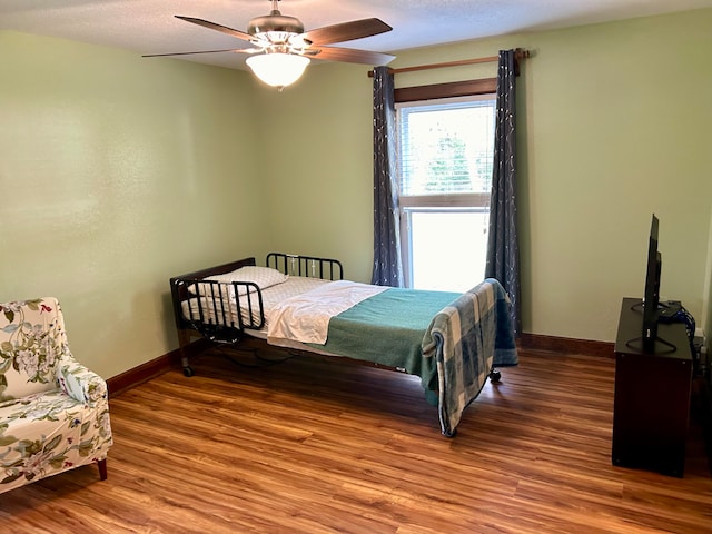 bedroom with wood-type flooring, ceiling fan, and a textured ceiling