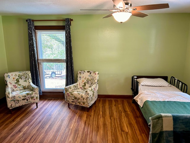 bedroom featuring ceiling fan, dark hardwood / wood-style floors, and a textured ceiling