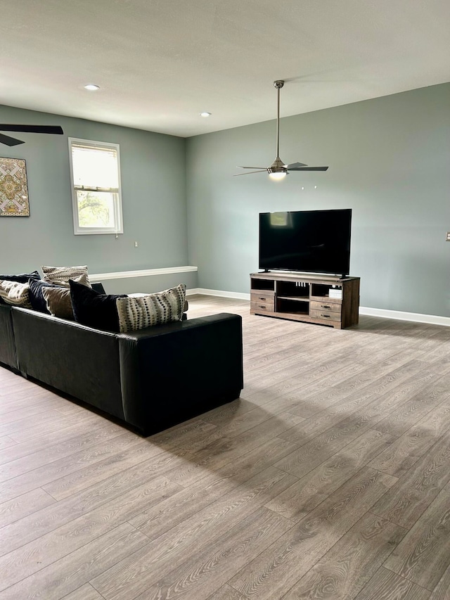 living room with ceiling fan and light hardwood / wood-style flooring