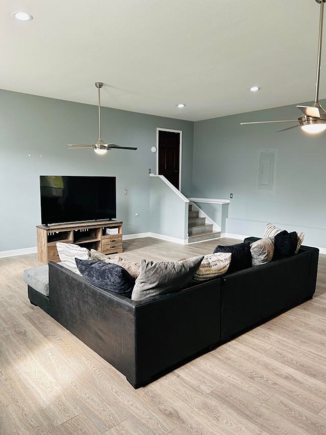 living room featuring light hardwood / wood-style floors and ceiling fan