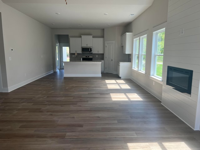 kitchen featuring dark wood-type flooring, white cabinetry, a kitchen island, a fireplace, and stainless steel appliances