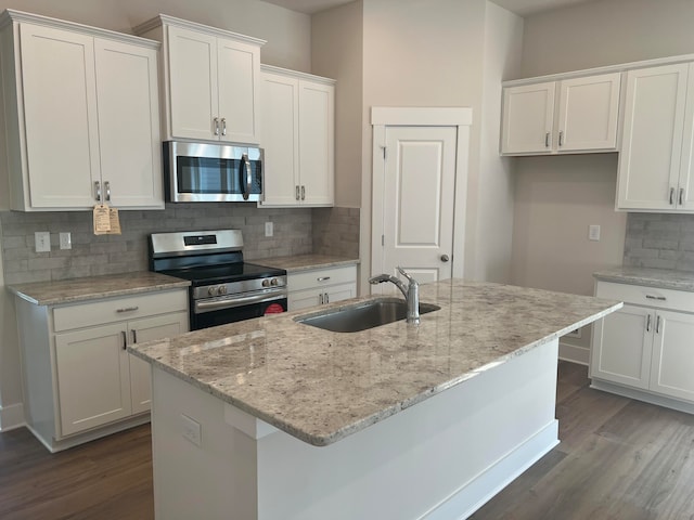 kitchen featuring an island with sink, sink, dark wood-type flooring, white cabinetry, and stainless steel appliances