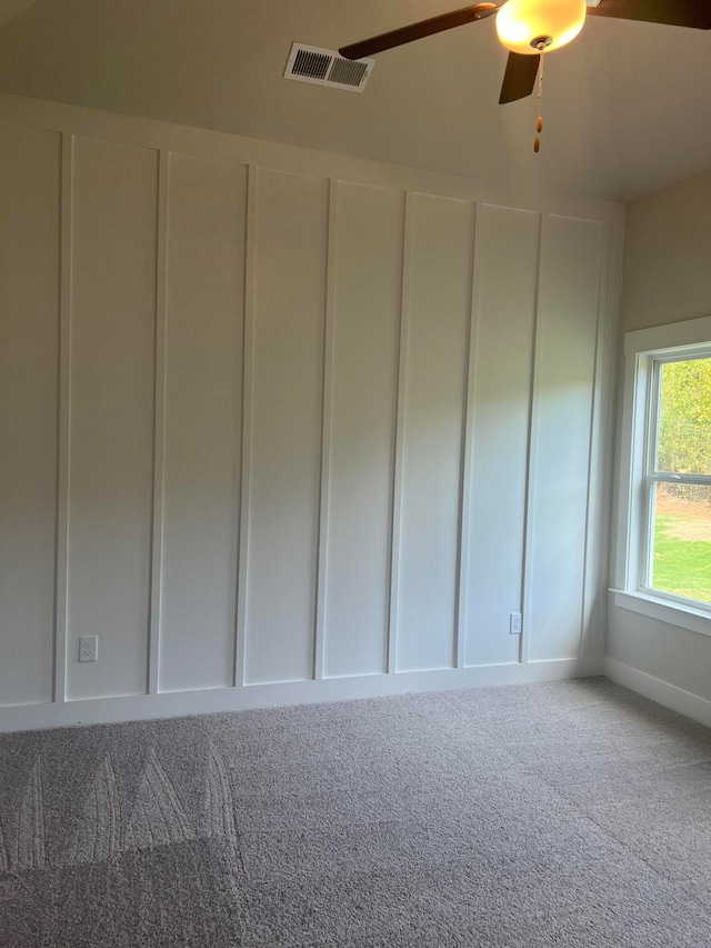 carpeted spare room featuring ceiling fan