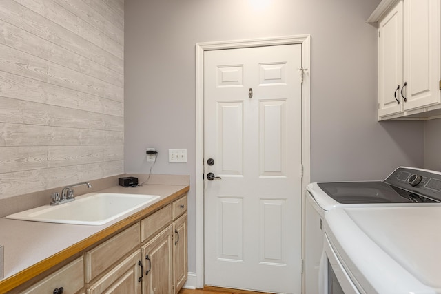 laundry area with cabinets, washer and dryer, and sink