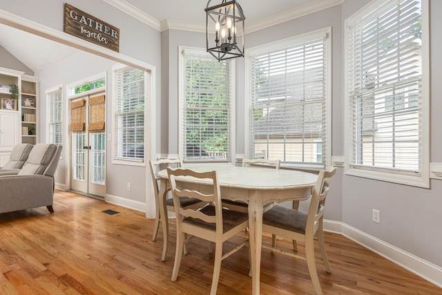 dining space with a healthy amount of sunlight, light hardwood / wood-style flooring, and a chandelier