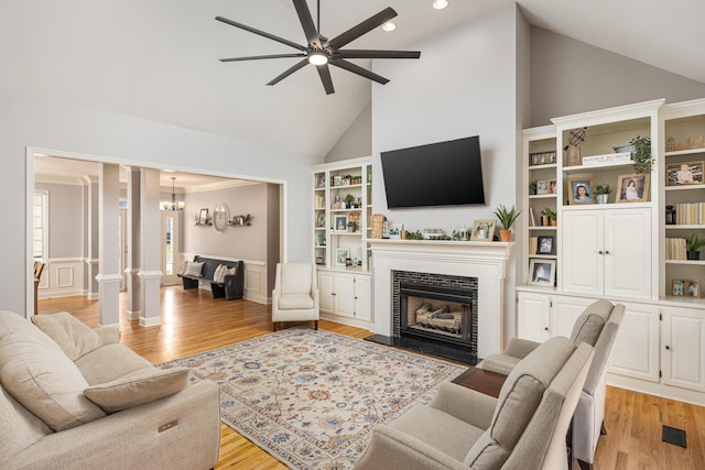 living room featuring decorative columns, light hardwood / wood-style floors, ceiling fan, and high vaulted ceiling