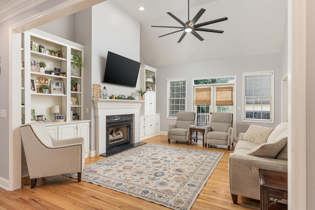 living room featuring light wood-type flooring, ceiling fan, and high vaulted ceiling