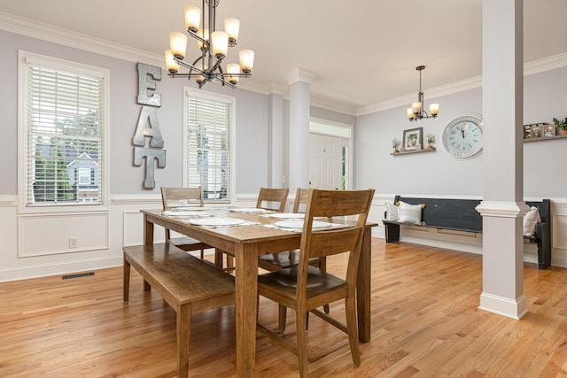 dining area featuring a chandelier, plenty of natural light, and ornate columns