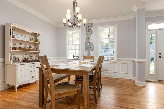 dining room featuring crown molding, light hardwood / wood-style floors, a chandelier, and plenty of natural light