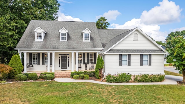 new england style home featuring a front yard and a porch