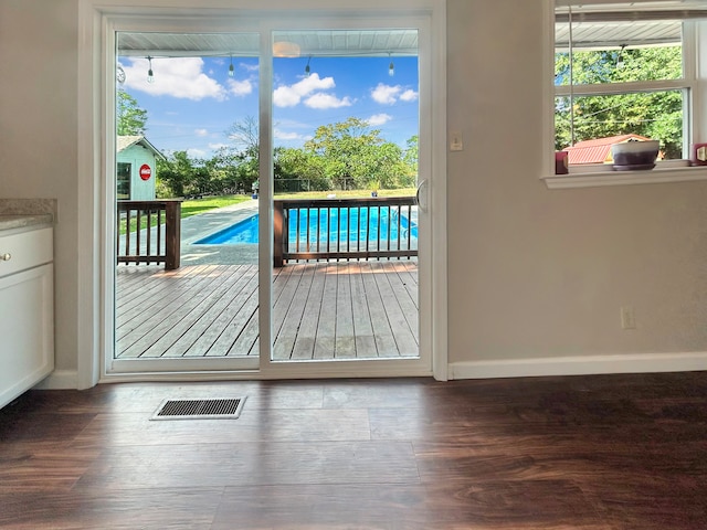 entryway with wood finished floors, visible vents, and baseboards