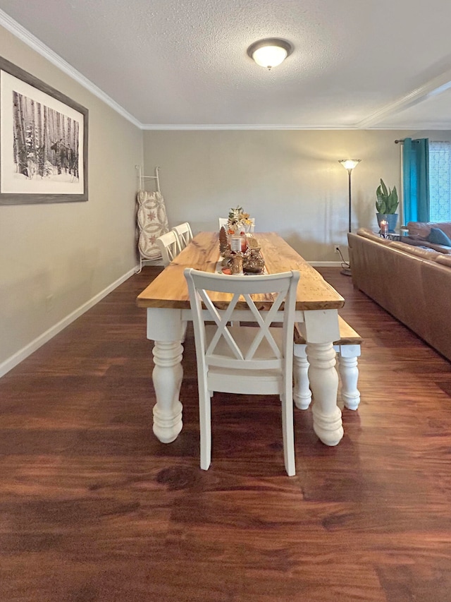 dining room featuring a textured ceiling, dark wood-type flooring, baseboards, and crown molding