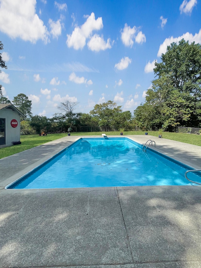 outdoor pool featuring a patio area and a yard