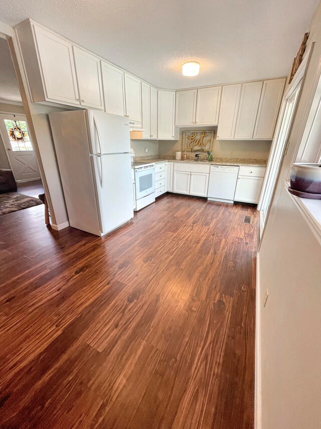 kitchen with a textured ceiling, white appliances, dark wood-style flooring, white cabinets, and light countertops