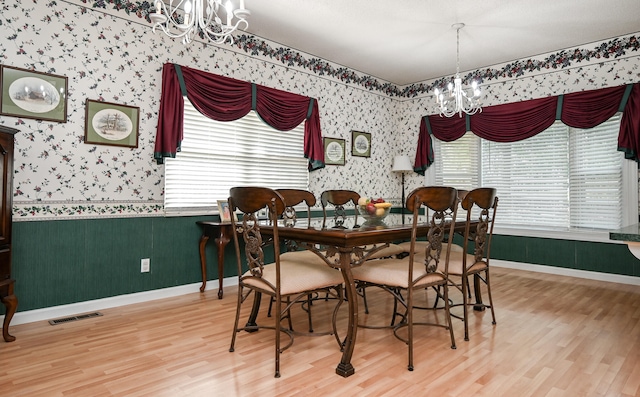 dining room with hardwood / wood-style floors and a chandelier