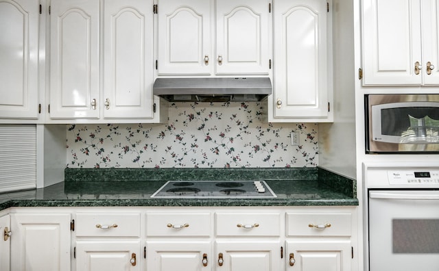 kitchen with white appliances, ventilation hood, and white cabinetry